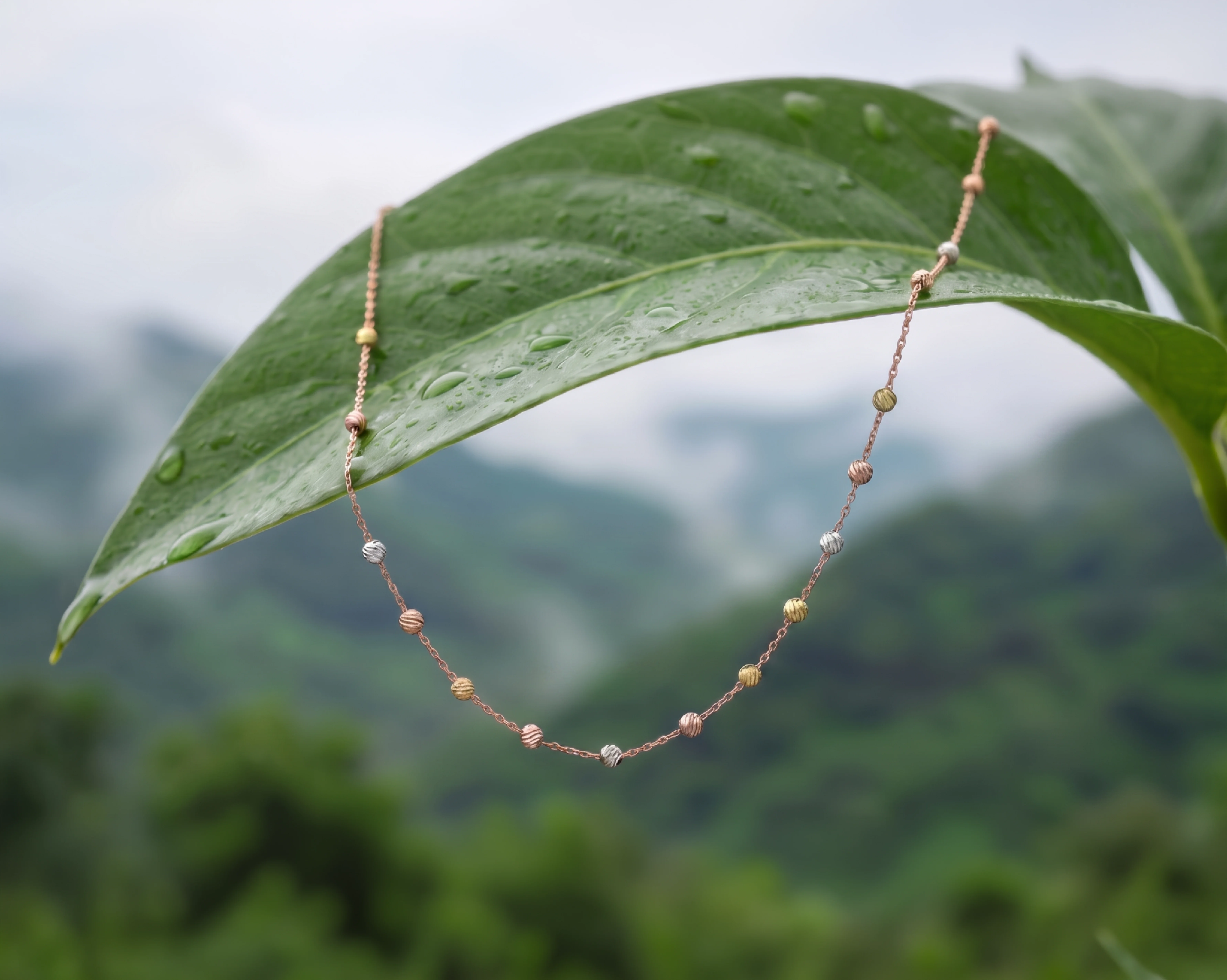 Champagne gold necklaces draped over weathered stone